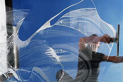 A person cleaning the window on a sunny day in Wichita Kansas