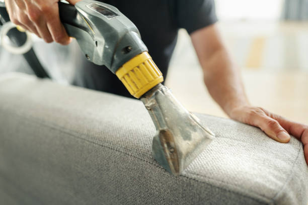 Close up picture of a person steam cleaning a sofa 