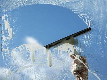 A squeegee cleaning the window on a sunny day in Wichita Kansas