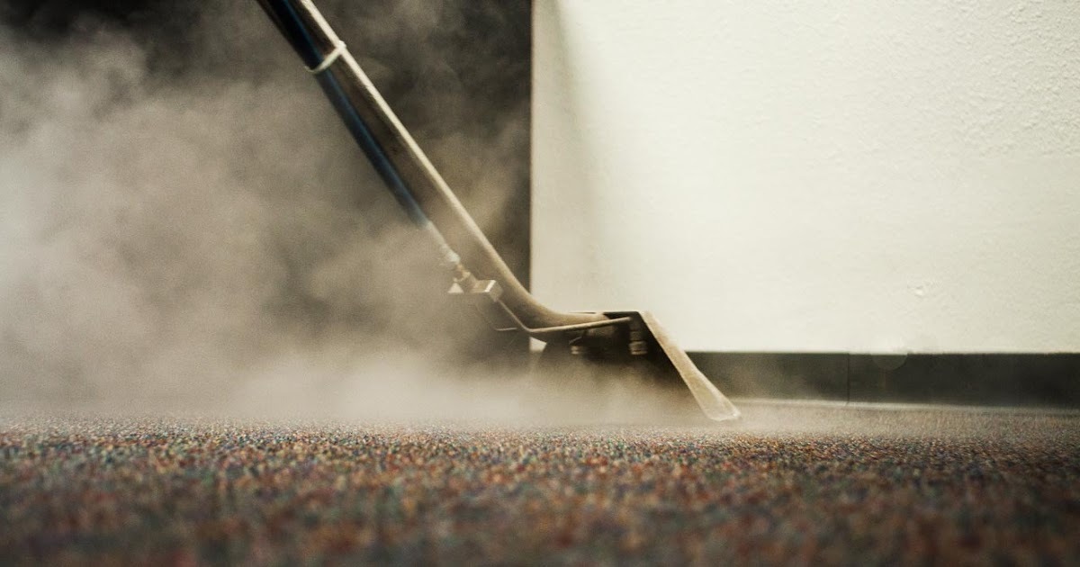 Close up picture of a person steam cleaning a sofa 