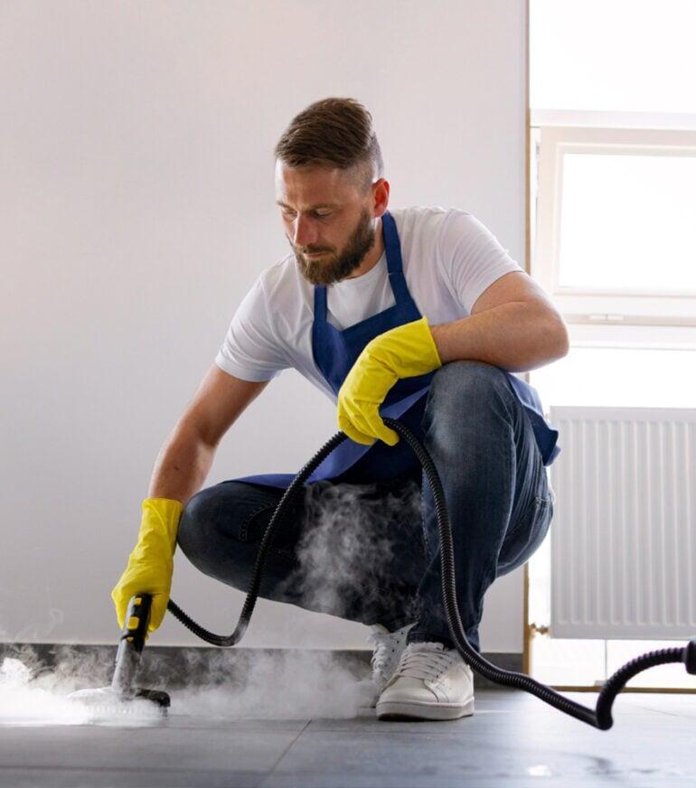 A man steam cleaning tile floor