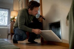 Homeowner inspecting moisture behind air vent