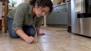 Homeowner checking a water drop on grout