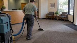 Technician extracting carpet in a business reception area
