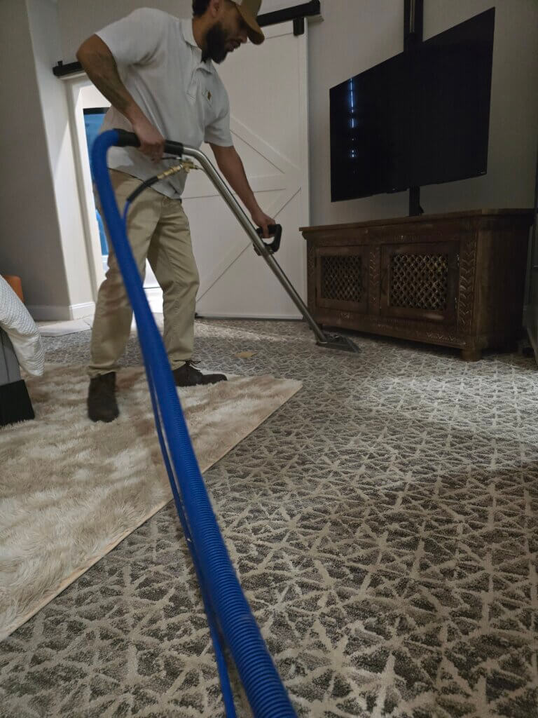Carpet cleaning technician performing hot water extraction in a Wichita KS home