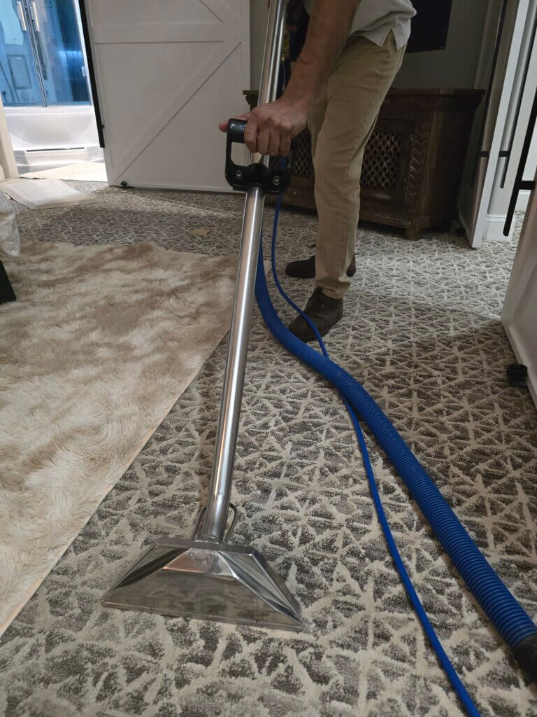 Carpet cleaning technician performing hot water extraction in a Wichita KS home